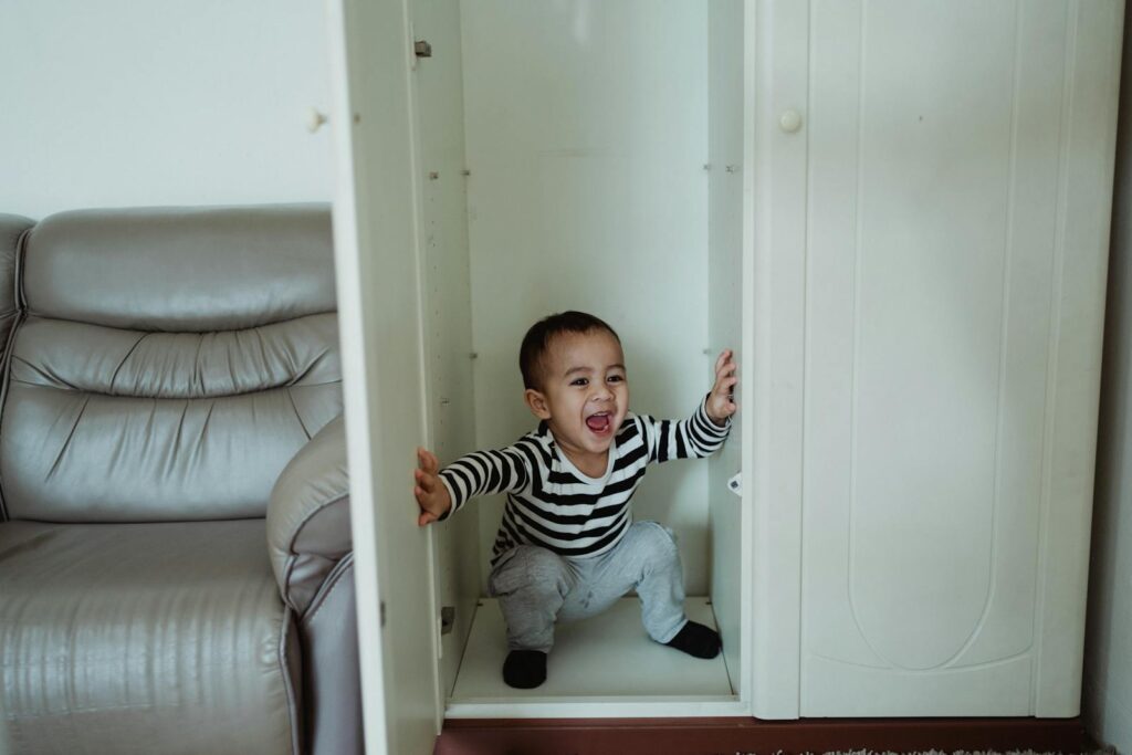 Baby Boy Playing Inside a White Wardrobe